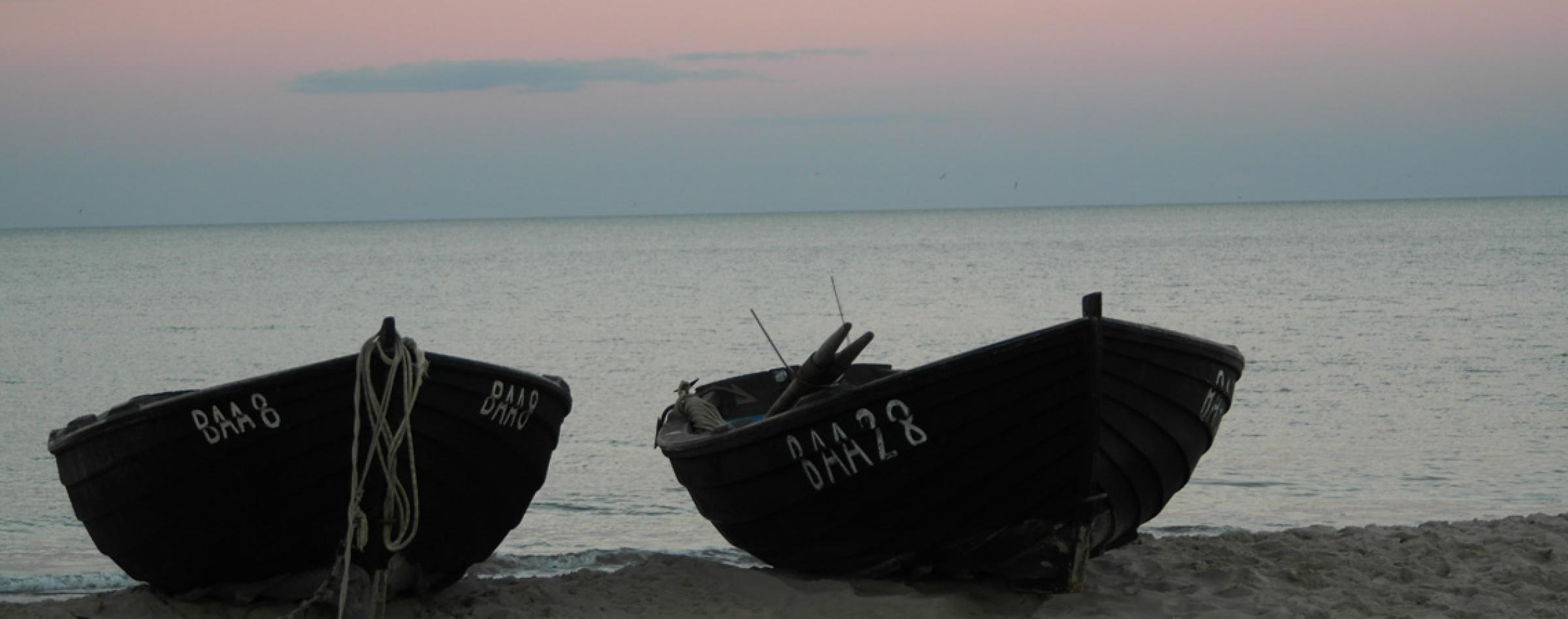 Boote am Strand zum Sonnenuntergang